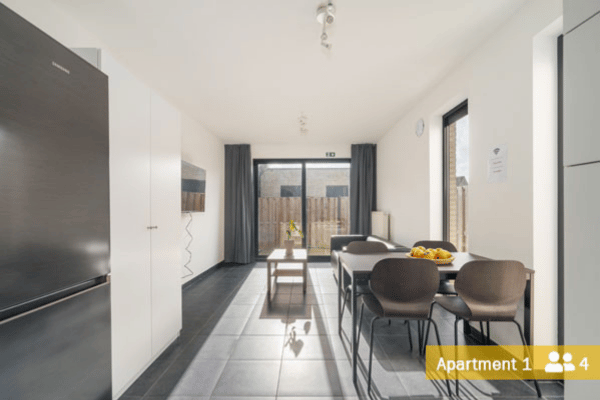 Spacious living and dining area with a fully equipped kitchen, designed for temporary housing.